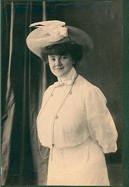 Photograph, Erma Bossi, by Unknown, 1905. Archivio Carla Pellegrini, Milan. Black and white studio photograph of a woman, Erma Bossi, wearing a white high-collared dress, a long beaded necklace, and a wide-brimmed hat decorated with a white bird ornament.